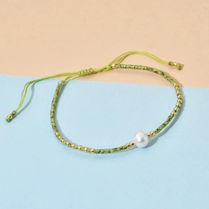 Detailed view of handmade beaded bracelet with light green beads and adjustable cord
