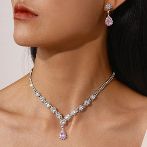Close-up of pink teardrop zircon necklace and earrings set on model with luxury sparkle