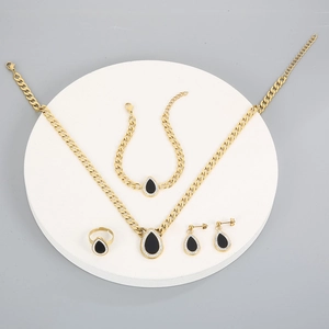 Detailed four-piece gold jewelry set with black teardrop pendants and crystal accents
