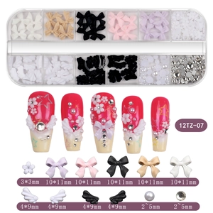 Detail of 12-grid nail art kit with 3D resin bows, pearls and assorted crystals for DIY