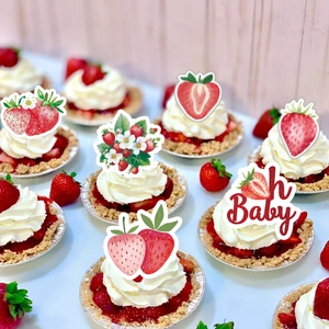 Detail of strawberry theme cake toppers and Oh Baby signs on fresh mini fruit tarts