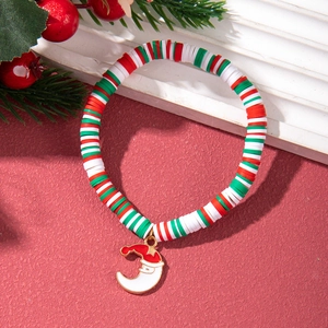 Close-up of Christmas polymer clay bracelet with Santa pendant on festive red background