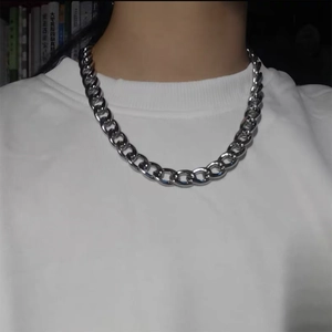 Close-up of a chunky silver stainless steel Cuban link chain necklace on a male model
