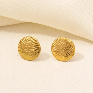 Detailed view of round gold stainless steel earrings with textured wavy surface finish