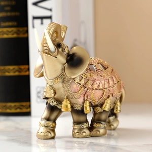 Golden elephant statue with pink patterned saddle and bells, decorative resin sculpture
