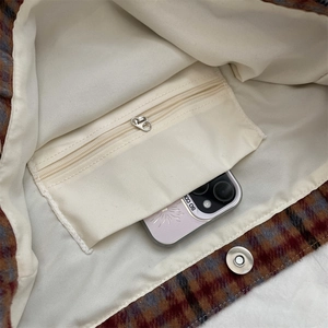 Interior detail of plaid tote bag featuring zip pocket and magnetic clasp closure