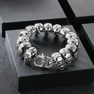 Detailed close-up of dark punk skull link bracelet with cross clasp on display box