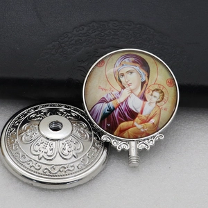 Detailed macro view of an Orthodox silver metal icon featuring Mary and Child on a glass face