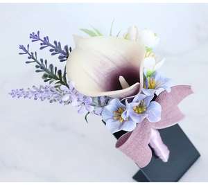 Detailed close-up of a PU calla lily boutonniere with lavender and silk ribbon