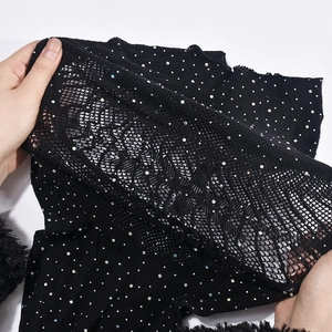 Détail macro du tissu en maille noire avec strass scintillants pour robe sans manches