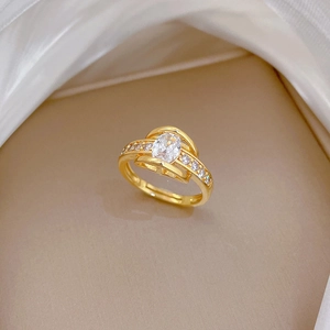 Adjustable gold ring with marquise cut crystal and side pave diamonds on beige fabric