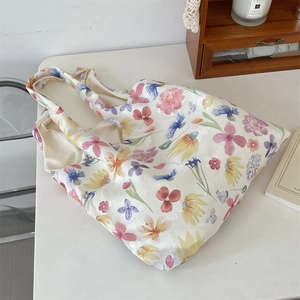Detail view of white mesh tote bag with vibrant pink, yellow and blue floral patterns