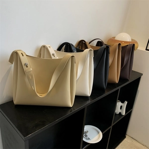 Five assorted colors of large PU leather tote bags displayed on a black shelf