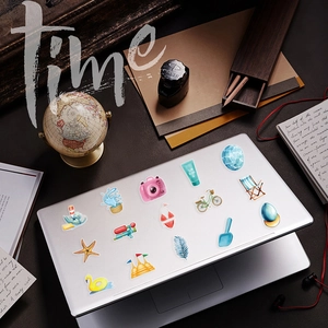 Detailed view of summer beach stickers featuring sunblock and camera icons on a laptop