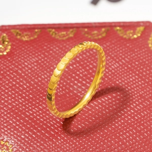 Macro detail of golden fish scale textured ring on a premium red jewelry box
