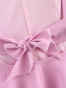 Détail d'un haut ajusté rose avec un grand nœud en tissu à l'arrière du vêtement