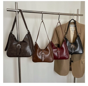 Détail de sacs bandoulière rétro à boucle en noir, marron, caramel et bordeaux cuir