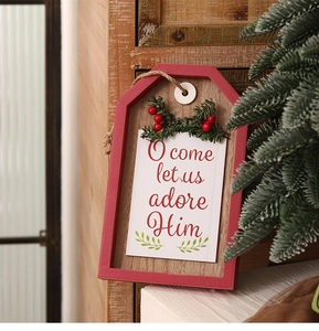 Detail of wooden Christmas door sign with pine branches and O come let us adore Him text