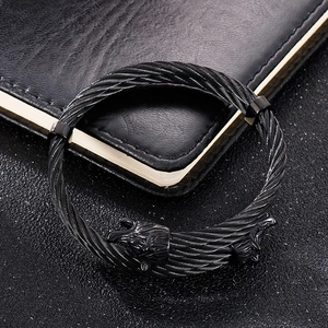 Close-up of black stainless steel braided cable bracelet with double wolf head terminals