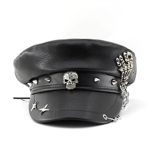 Detail of punk black PU leather flat top hat with metal skull, studs and silver chains