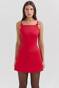 Détail de la robe rouge courte avec nœuds aux épaules et coupe trapèze élégante