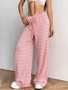 Detail of pink and white striped knit trousers featuring drawstring elastic waistband
