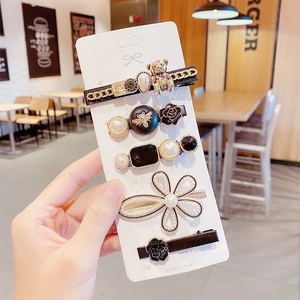 Detail showing 5-piece hair clip set with pearls, bear, rose motifs and Loveme text