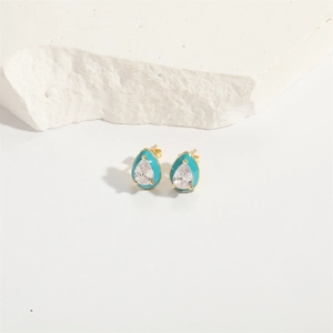 Close-up of teardrop enamel bow earrings with zircon stones and gold-plated finish