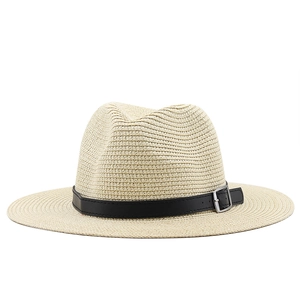 Close-up of beige woven straw hat with black leather band and silver buckle detail