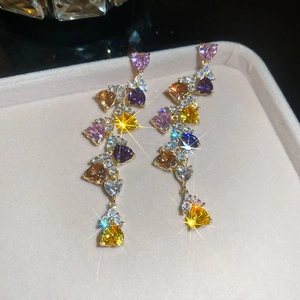 Macro detail of luxury long tassel earrings with multicolored heart-shaped zircon stones