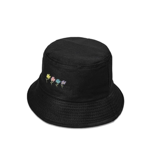 Détail de la broderie florale colorée sur un chapeau bob en coton noir avec bord surpiqué