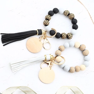 Close-up of silicone and wood bead keychains with checkerboard patterns and leather tassels