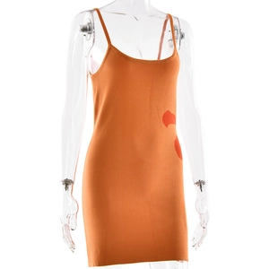 Détail d'une robe en tricot orange avec des motifs abstraits rouges et de fines bretelles