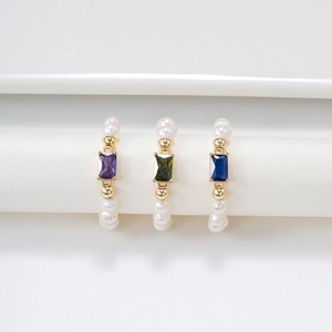 Drei Goldperlenringe mit lila, grünen und blauen quadratischen Edelsteinen in der Detailansicht