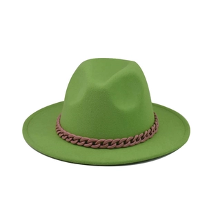 Détail du chapeau fedora en feutre vert avec une chaîne décorative en plastique rose