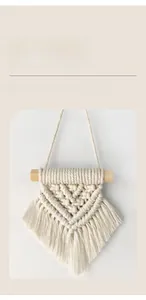 Detail of hand-woven macrame wall hanging with natural cotton rope and wooden dowel