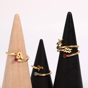 Golden zodiac sign rings set with colorful gemstones displayed on professional cone stands