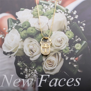 Elegant gold necklace with a zircon-encrusted shield cross pendant and white flower backdrop