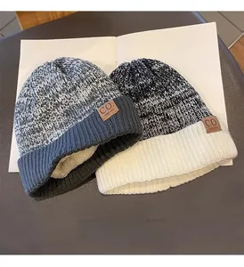 Detail of winter knit beanie with thick faux fleece lining and stitched leather logo patch