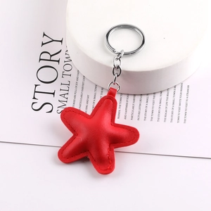 Close-up of red leather star keychain with fine stitching and silver metal ring