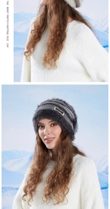 Detail of dark grey knit plush beanie with sequins and logo tag on snowy backdrop