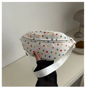 Dettaglio di un marsupio in tela bianca con pois colorati e tracolla bianca regolabile
