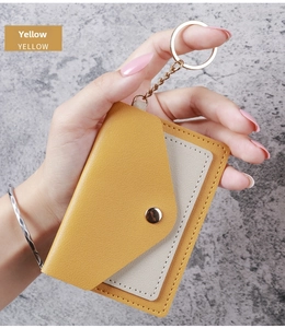Detail of yellow and gray leather card holder keychain with secure gold metal snap button