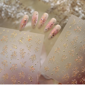 Detail of elegant gold firework and star nail stickers with French gradient effect