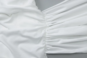Gros plan sur le tissu froncé blanc avec des plis élégants et une texture douce
