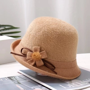 Detailed view of camel knitted bucket hat featuring elegant side flower and ribbon bow