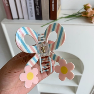 Close-up of blue and pink striped butterfly hair claw clip with floral details