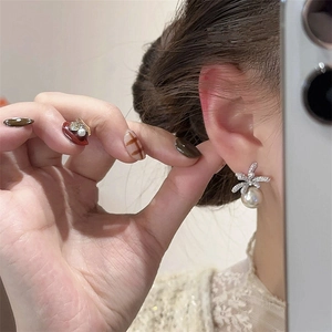 Elegant silver bow stud earrings with sparkling crystals and hanging white pearls