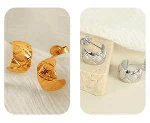 Detail of gold and silver C-shaped hoop earrings featuring a luxury quilted texture