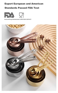 Detail of rose gold and gold stainless steel measuring cups with engraved scale on wooden tray